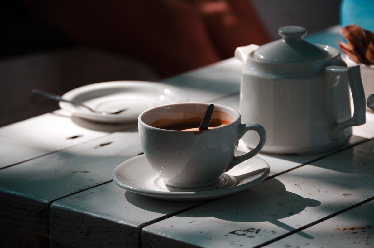 Šoljica kafe na stolu obasjana jutarnjim suncem