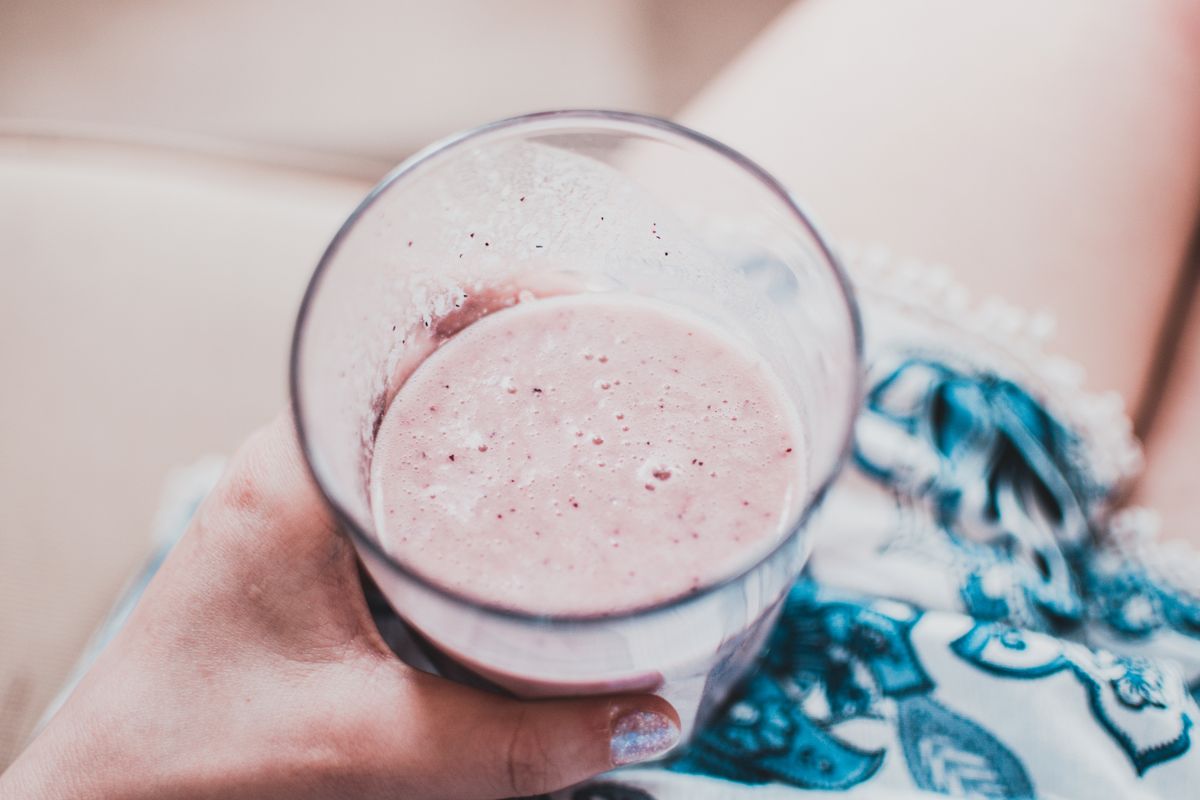 Čaša voćnog smoothieja od jagoda u ruci